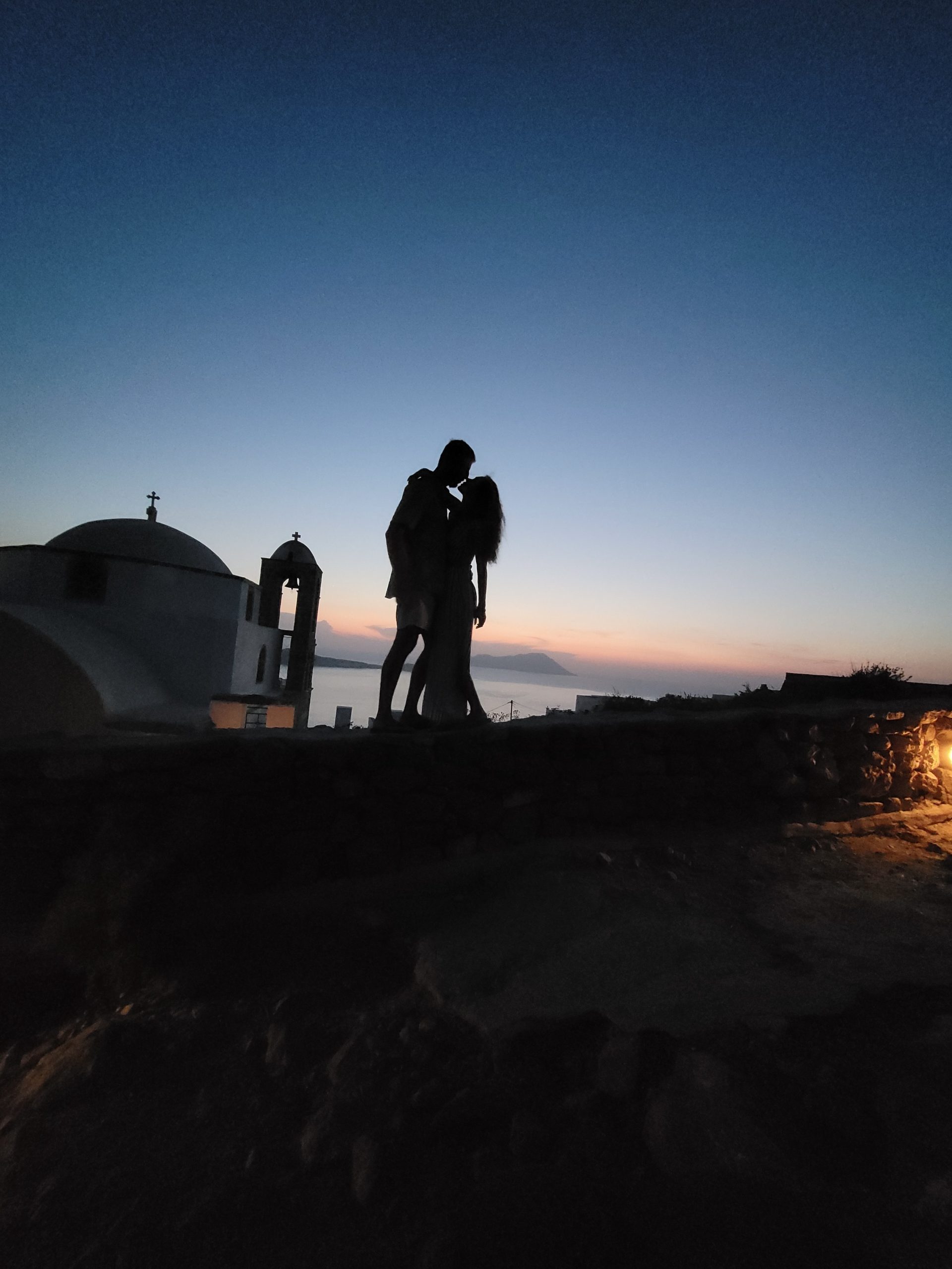 Silhouette of Kait and her boyfriend at sunset near the church and bell tower at Plaka Castle in Milos.